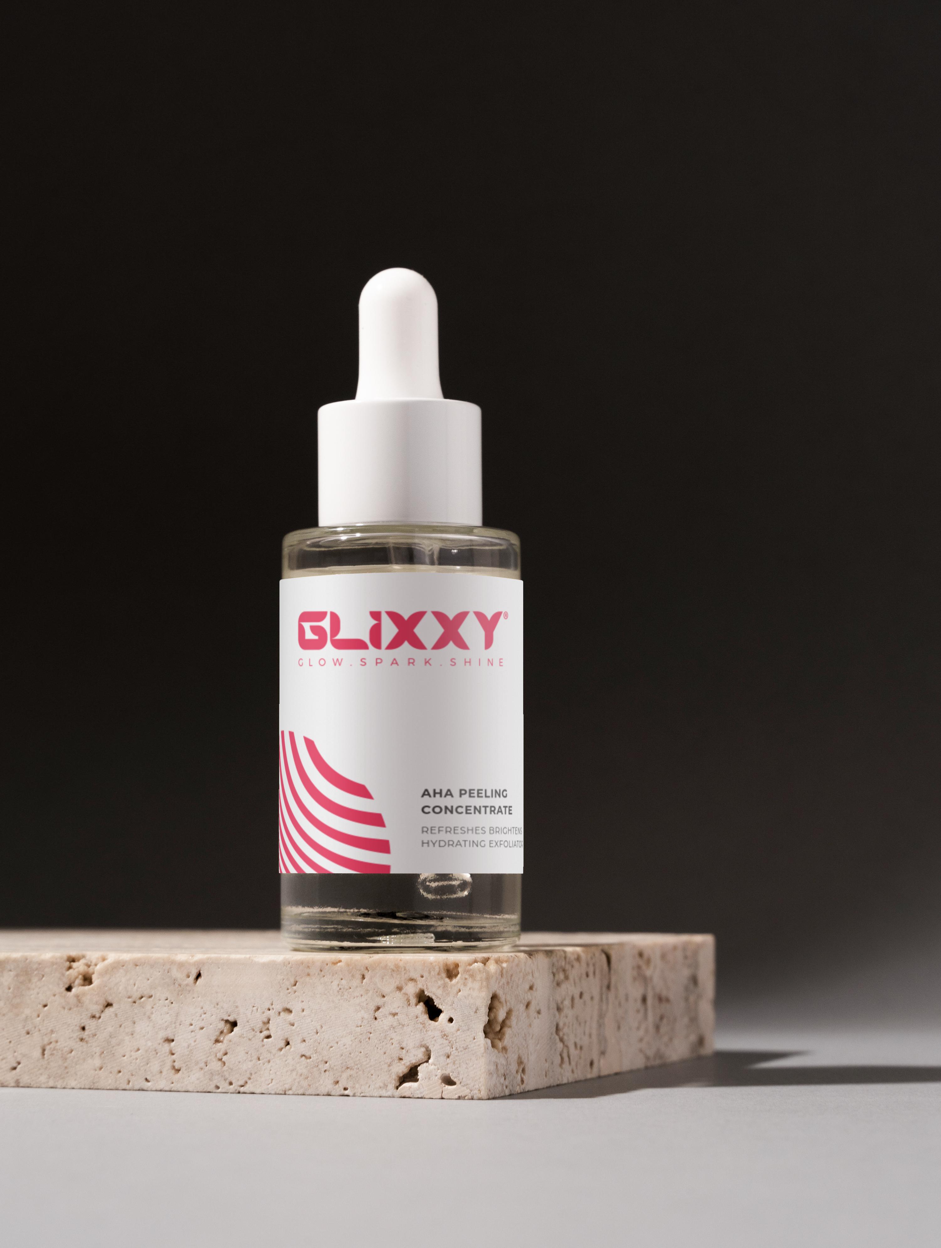 Glixxy skincare serum bottle on a stone surface with a dark background