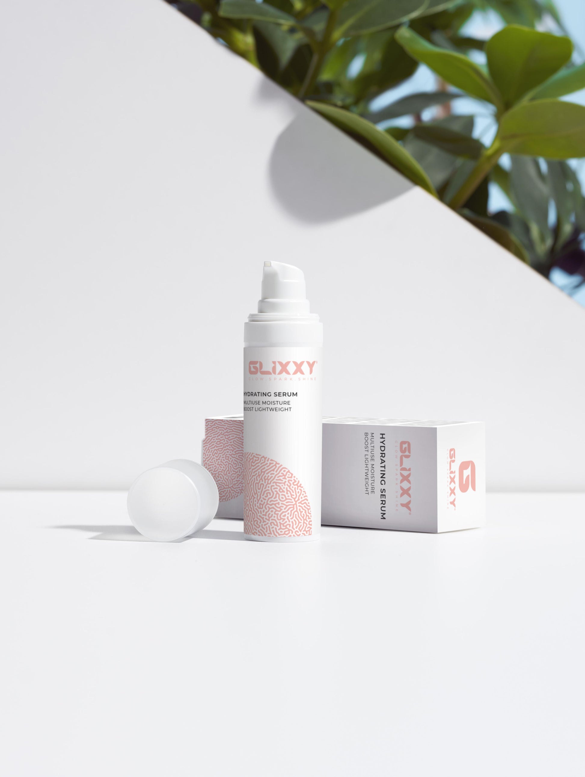 Glixxy skincare serum bottle and packaging on a white background with greenery.