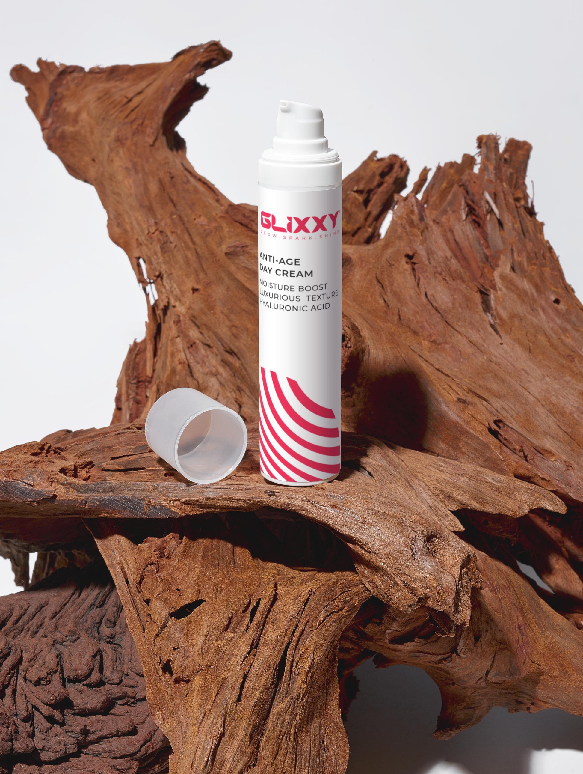 Glixxy bottle with red and white design on a wooden surface containing The Age-Defying Trio Collection Box