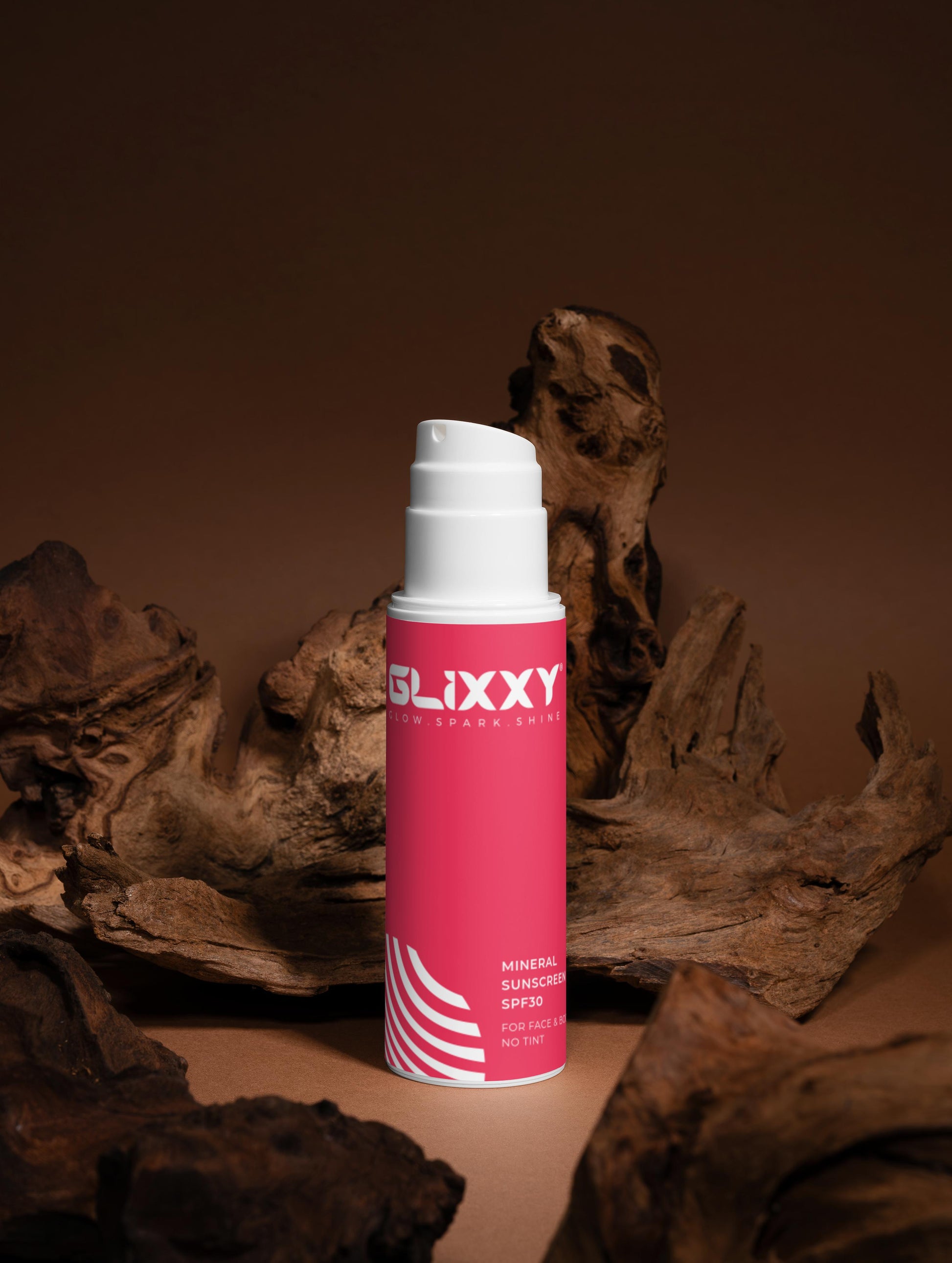 Glixxy Cream bottle on a brown background with natural elements