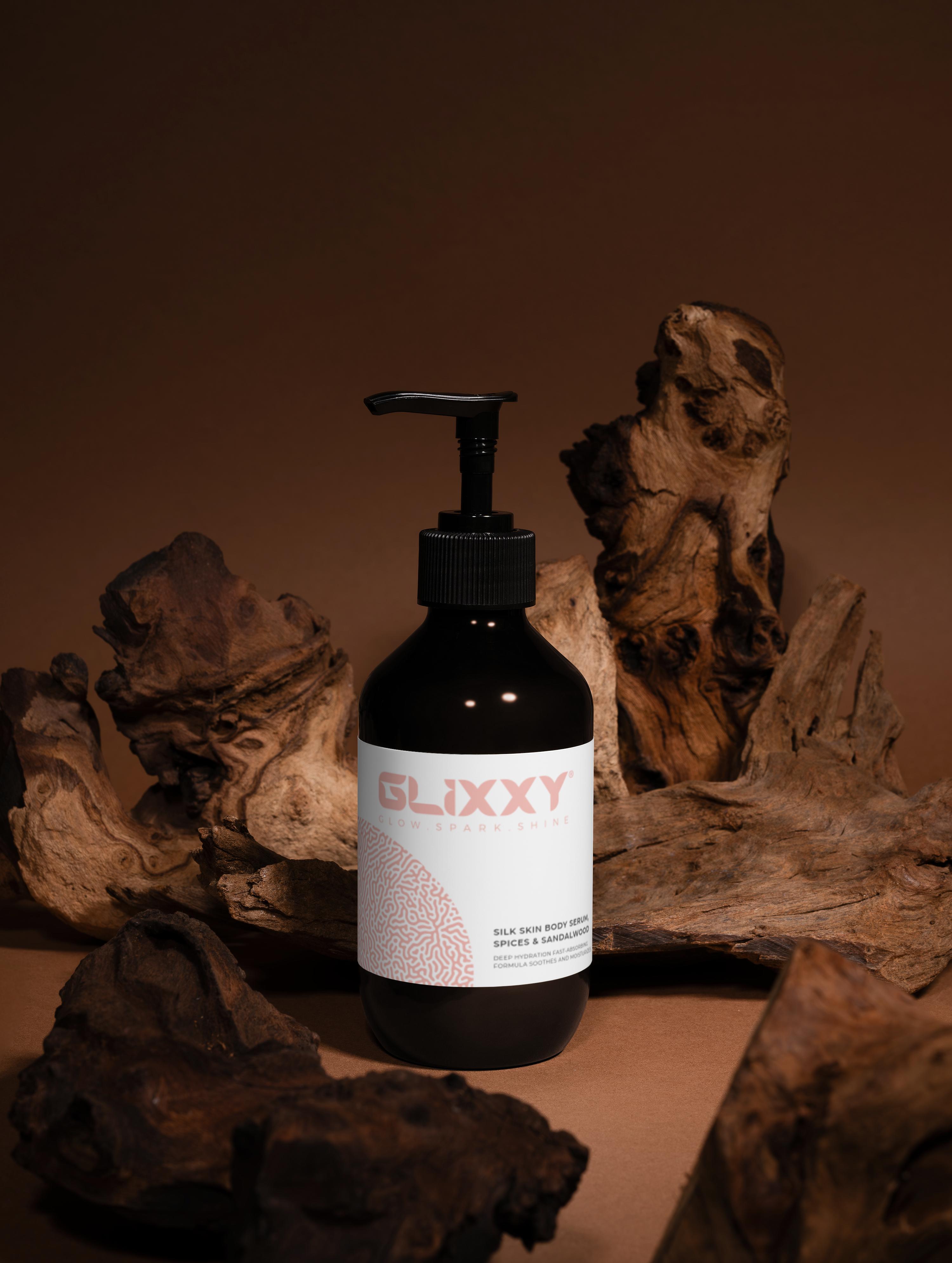 Glixxy body serum bottle with pump dispenser on a wooden background