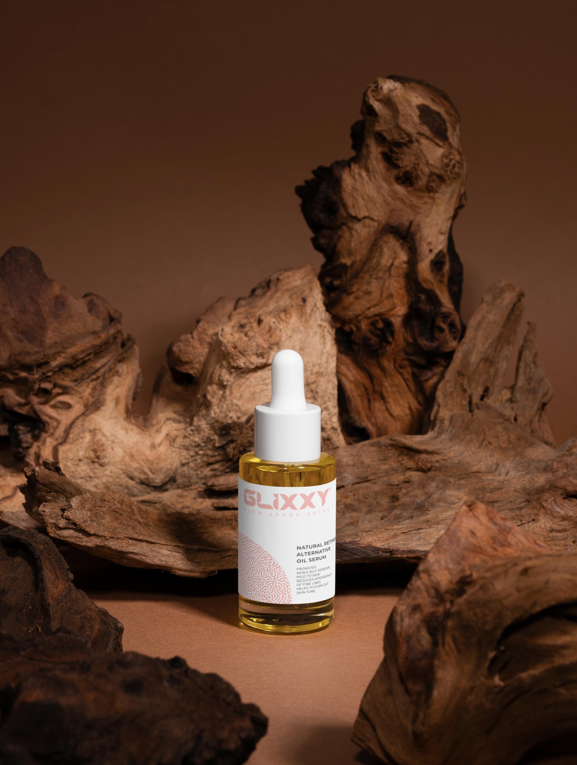 Glixxy natural retinol alternative oil serum skincare bottle with dropper on a brown background with wooden textures