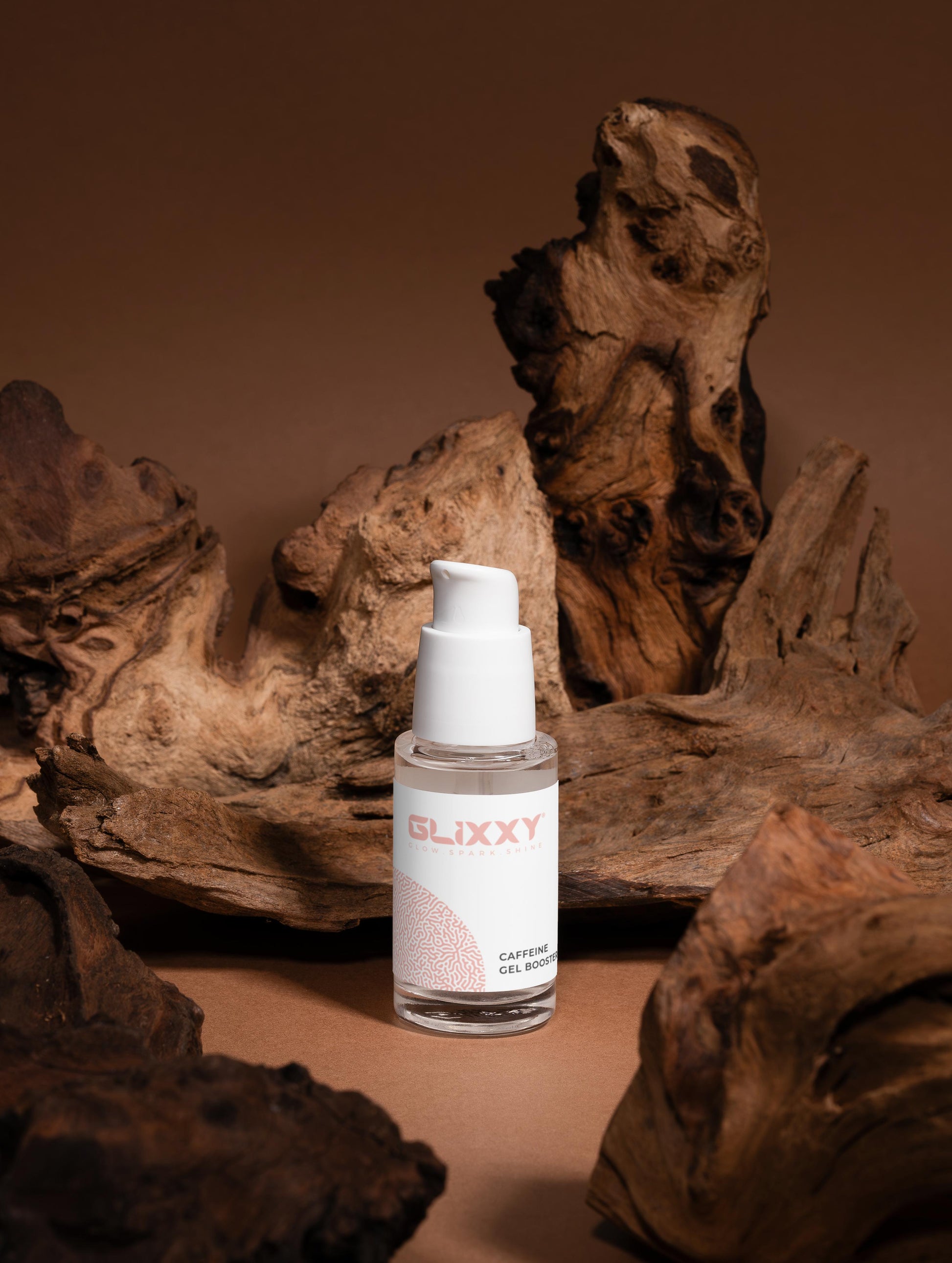 Glixxy skincare bottle on a brown background with natural wood elements