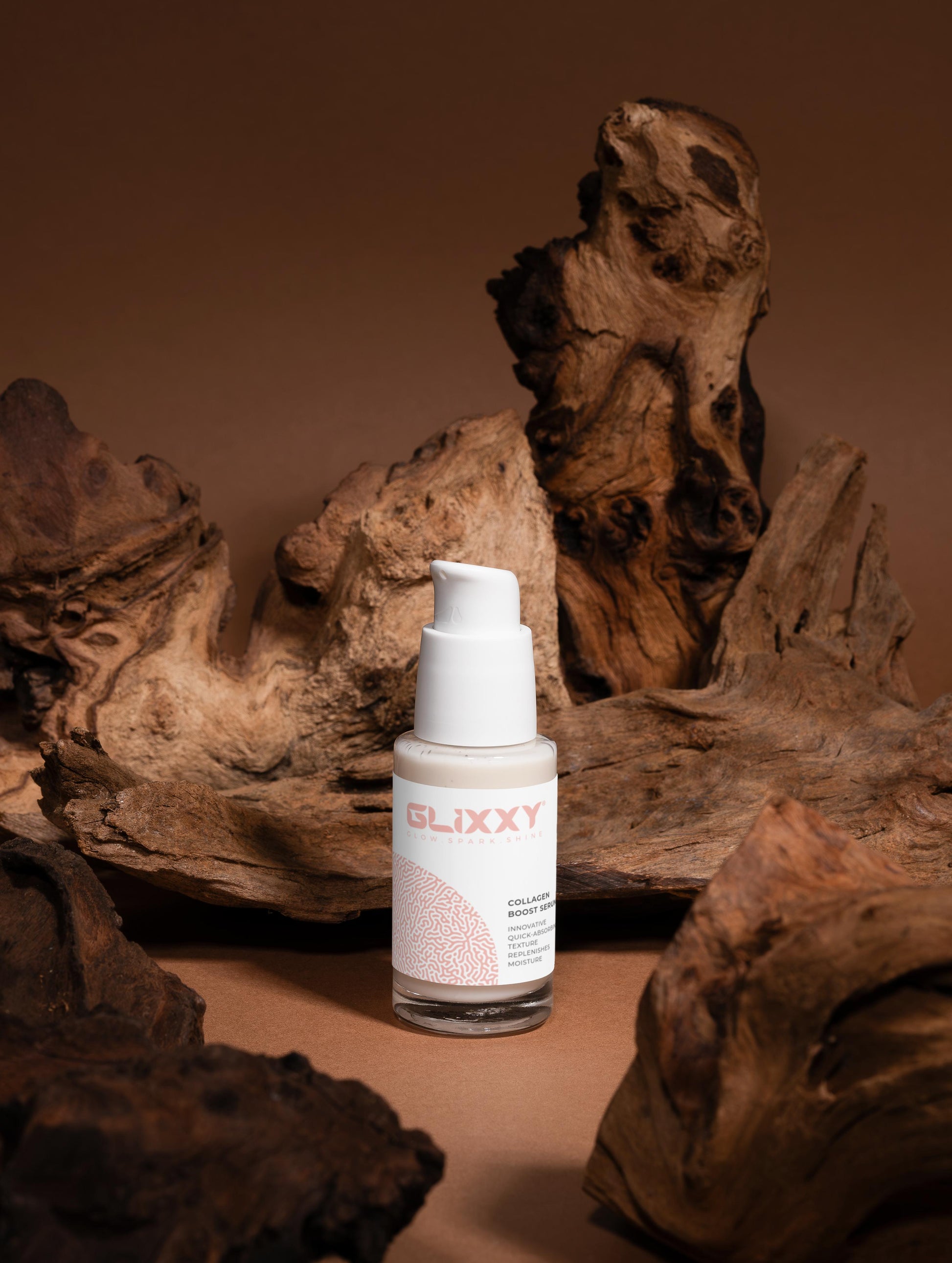 Skincare bottle labeled 'Glixxy' on a brown background with natural wood elements.