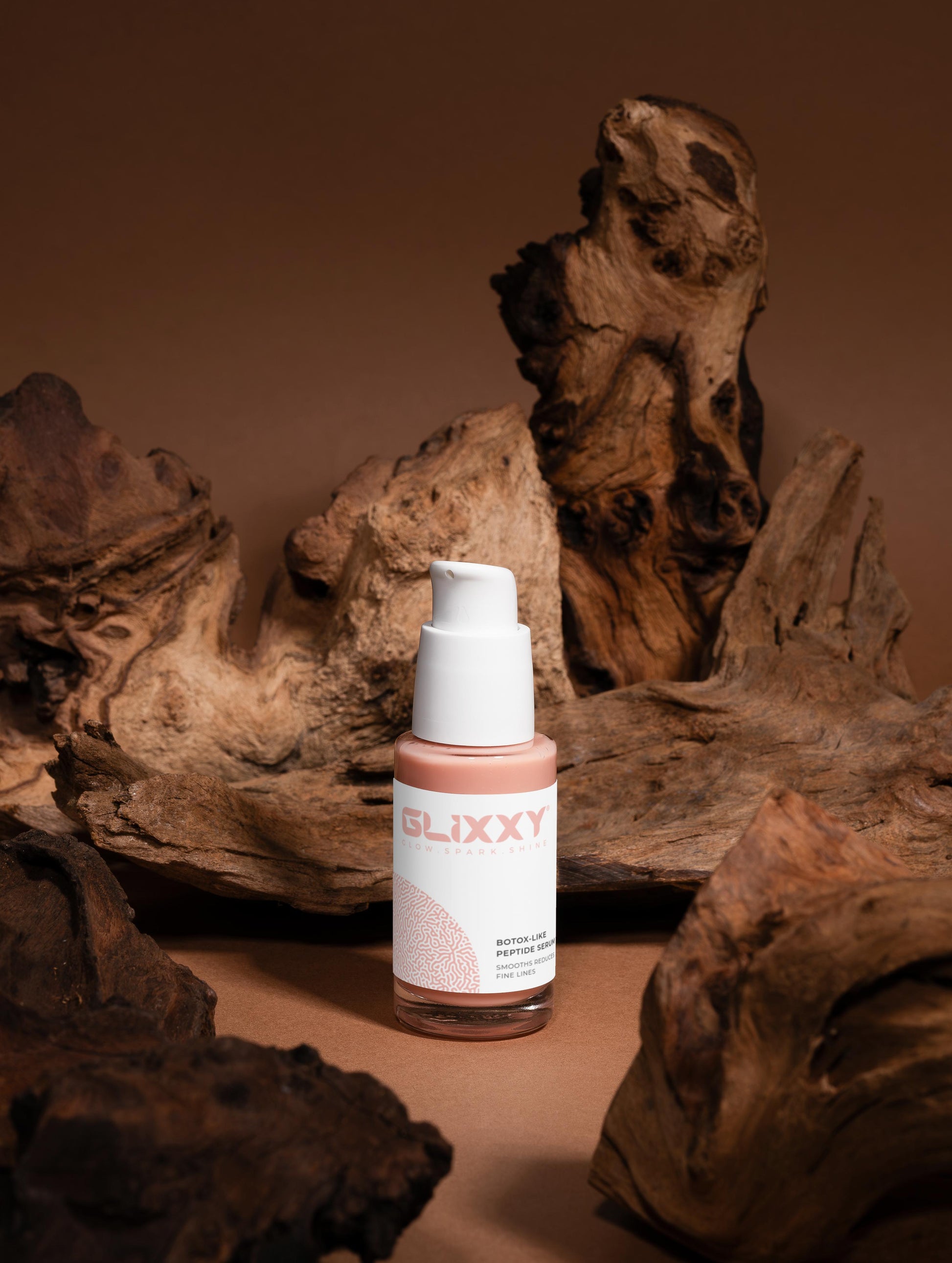 Glixxy bottle on a brown background with natural wood elements