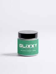 Glixxy soft wax candle in a green container on a white background