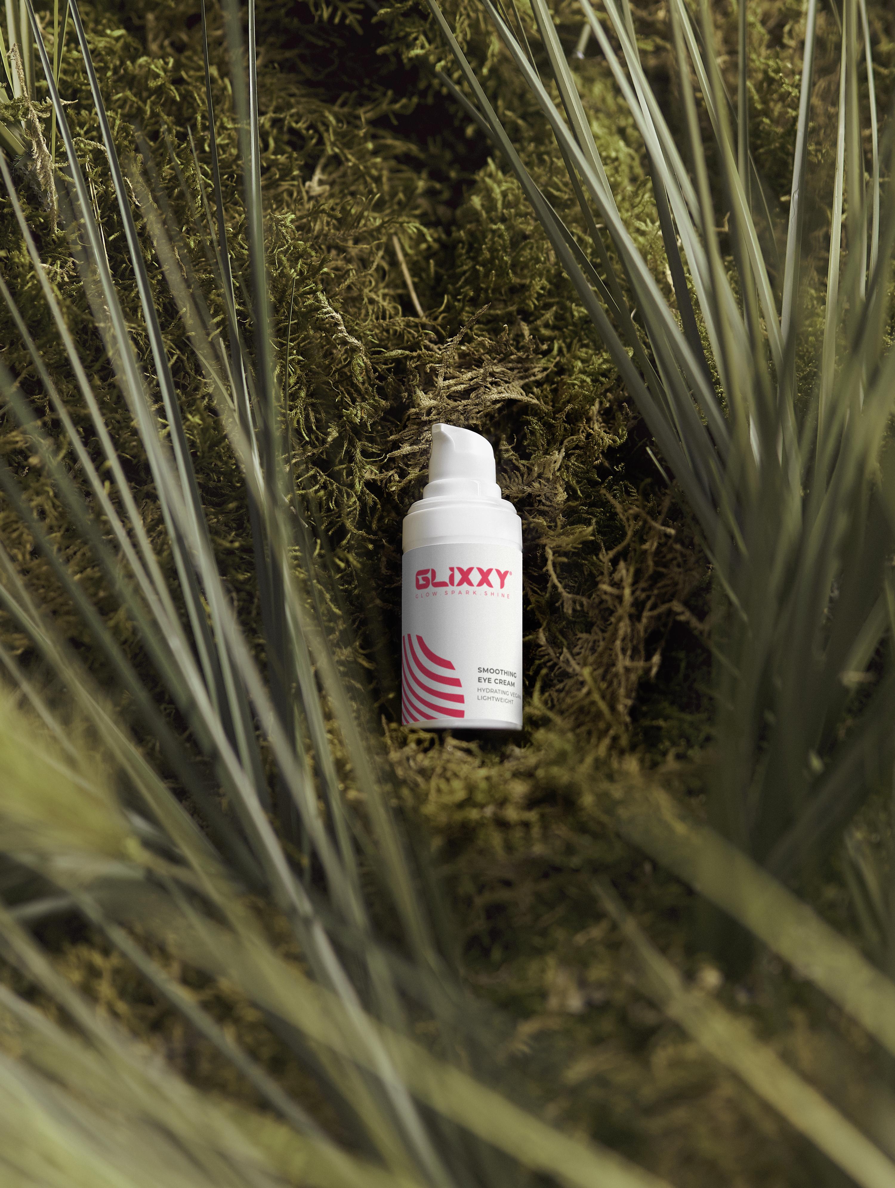 White spray bottle with red label on a bed of green moss and grass