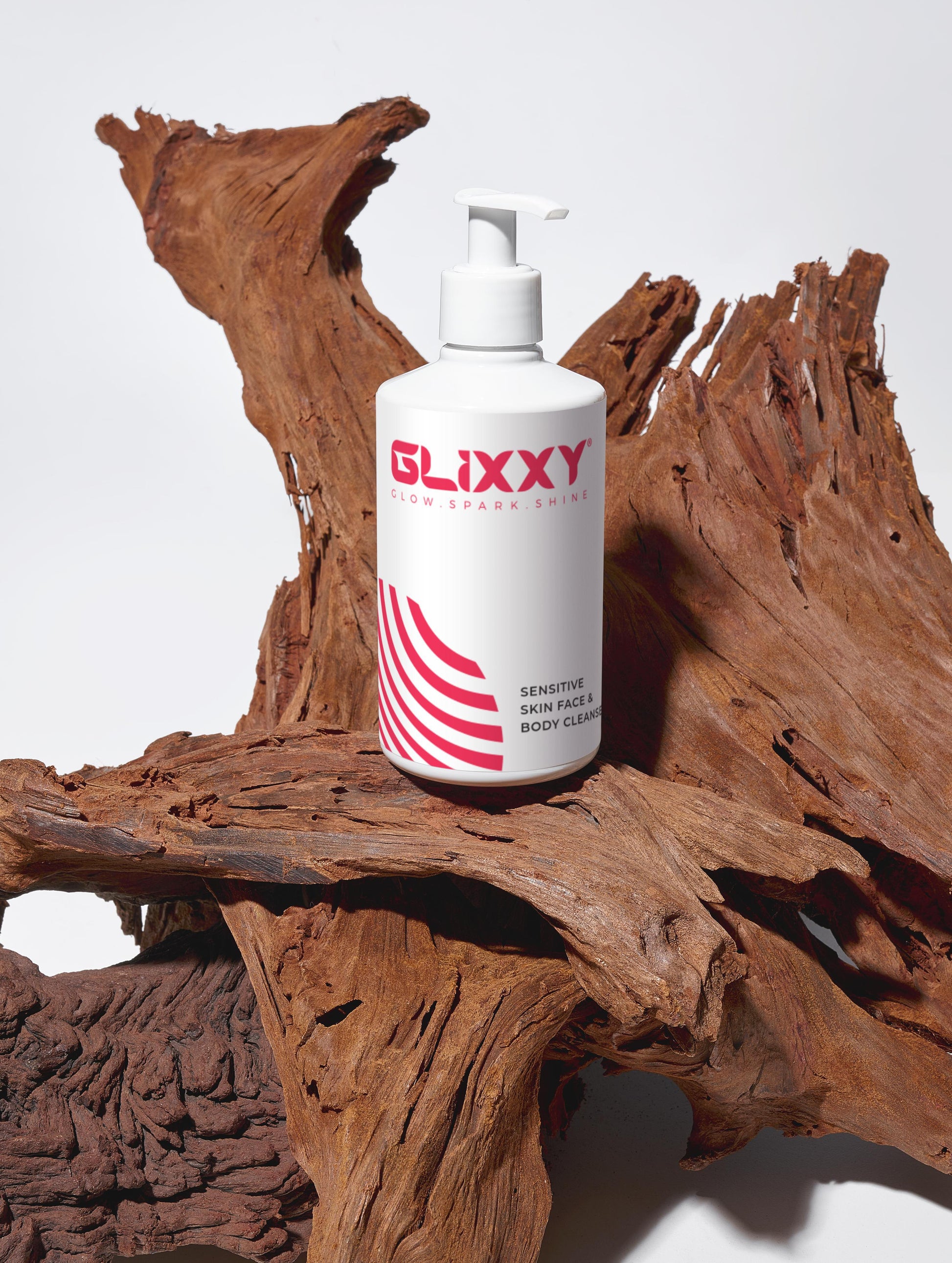 Glixxy best facial cleanser for sensitive skin bottle on a wooden surface with a white background