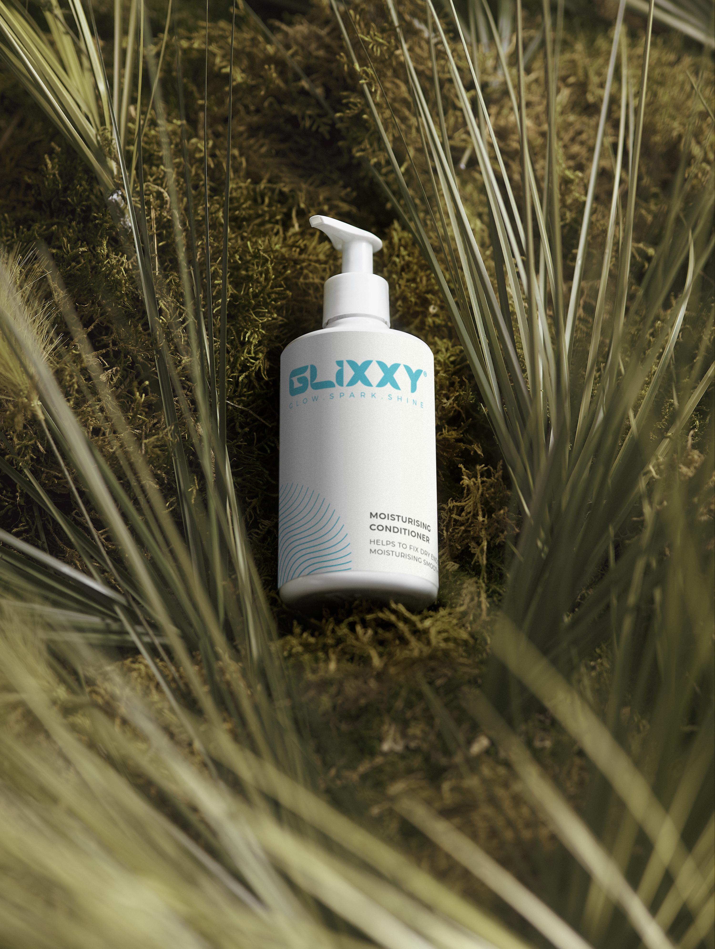 Glixxy best moisturising conditioner for dry hair bottle on a natural background with plants