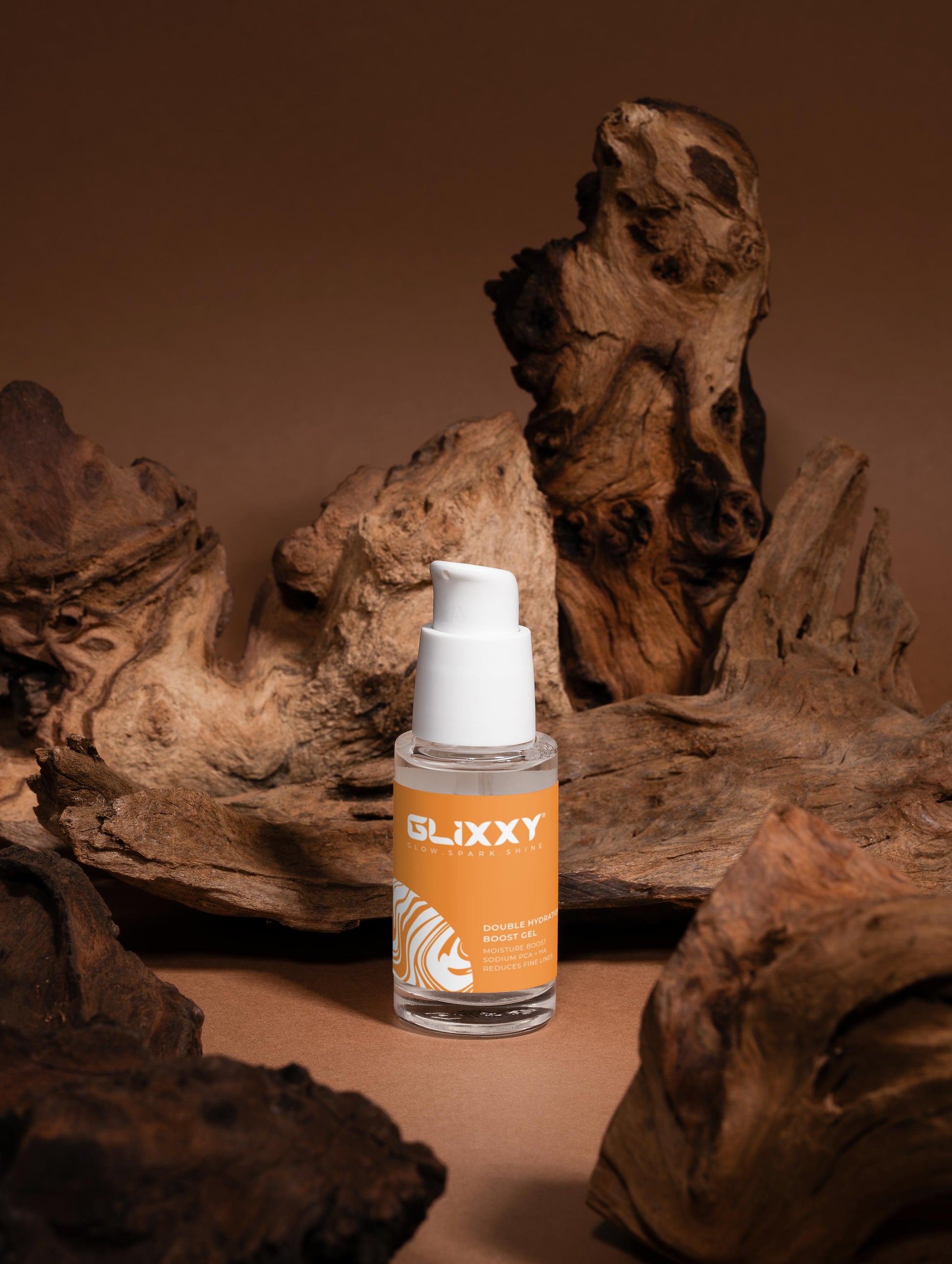 Glixxy skincare bottle on a brown background with wooden textures