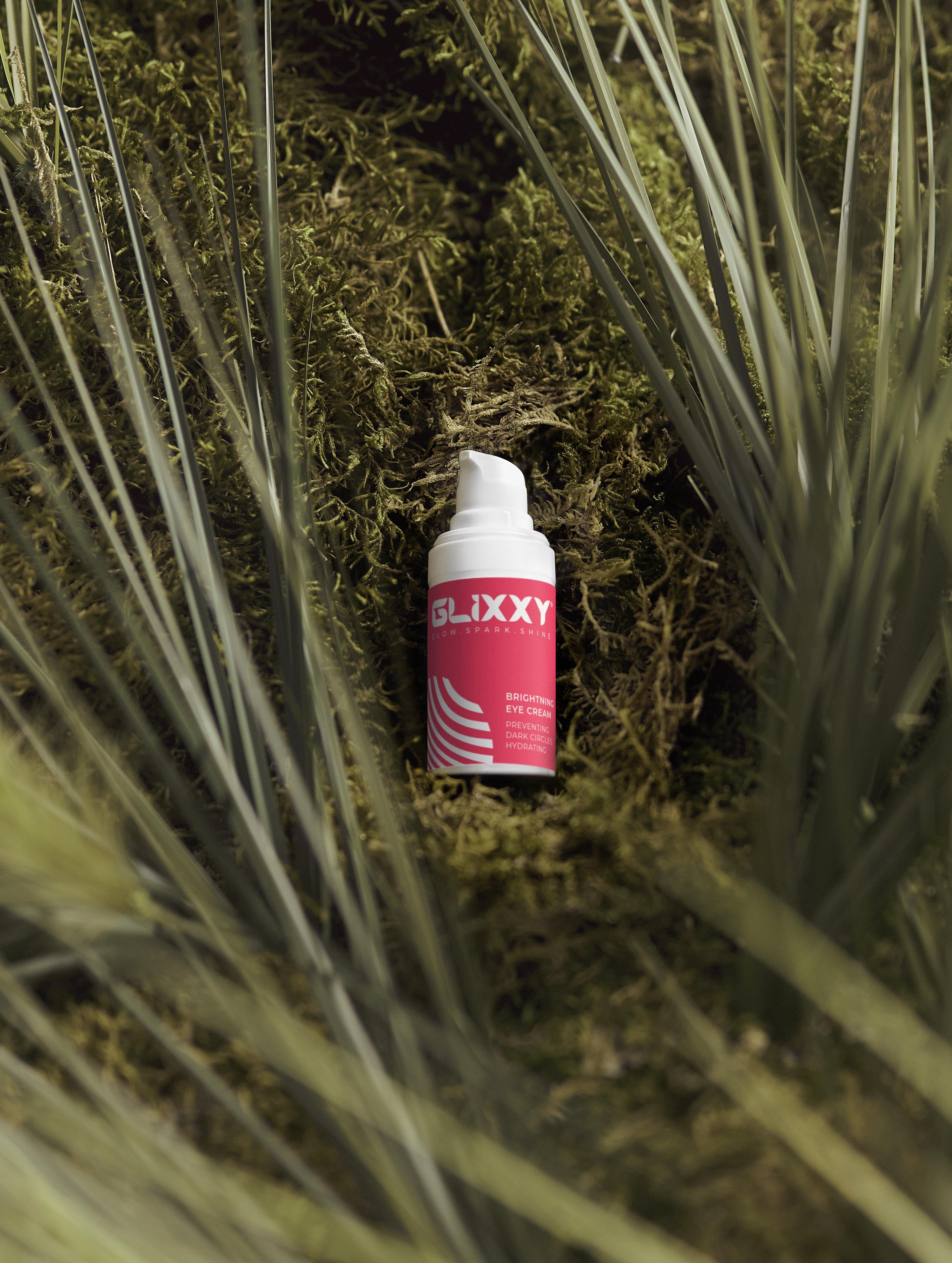 glixxy brightning eye cream bottle in a grassy area
