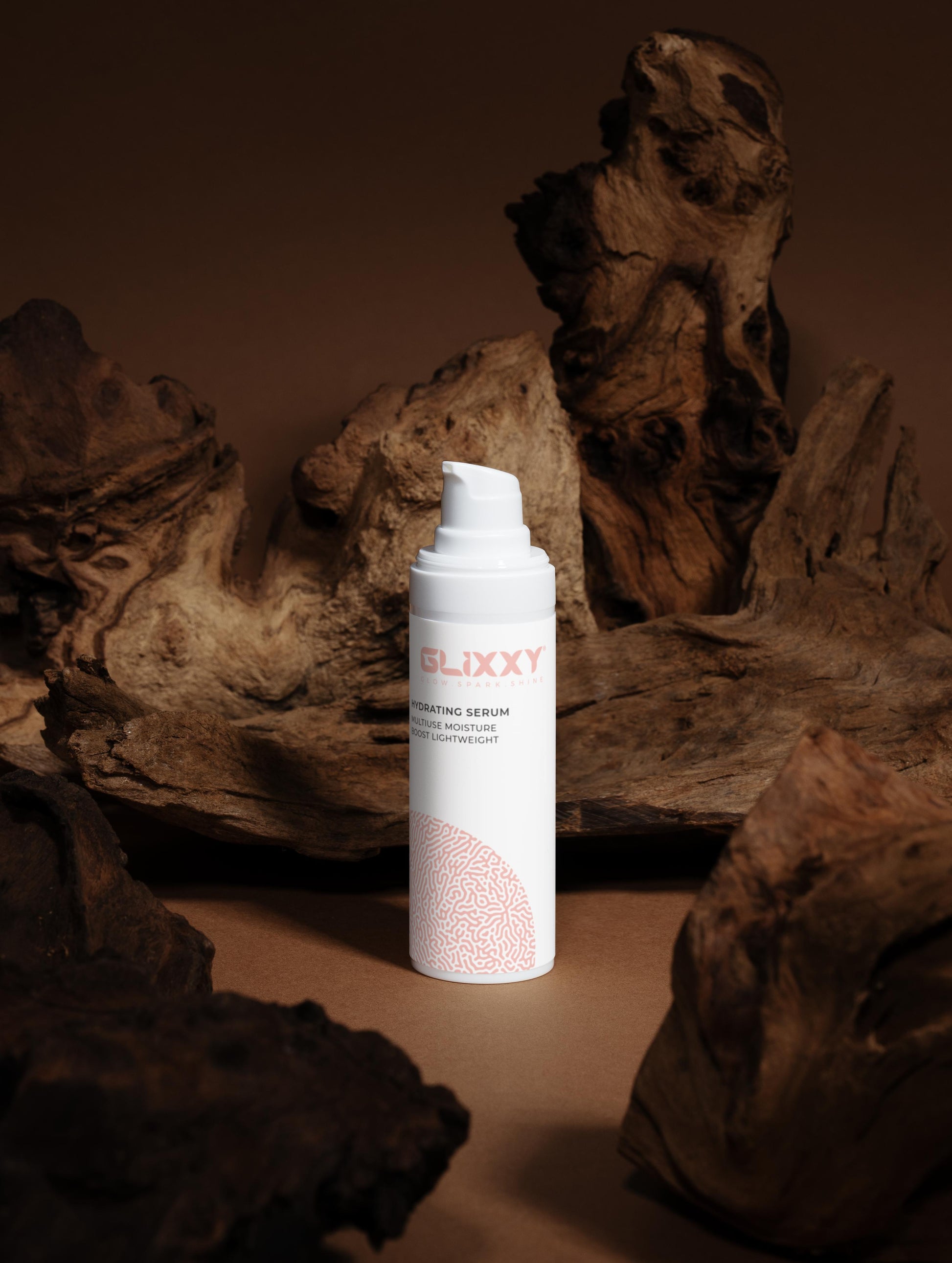 Glixxy serum bottle on a textured brown background