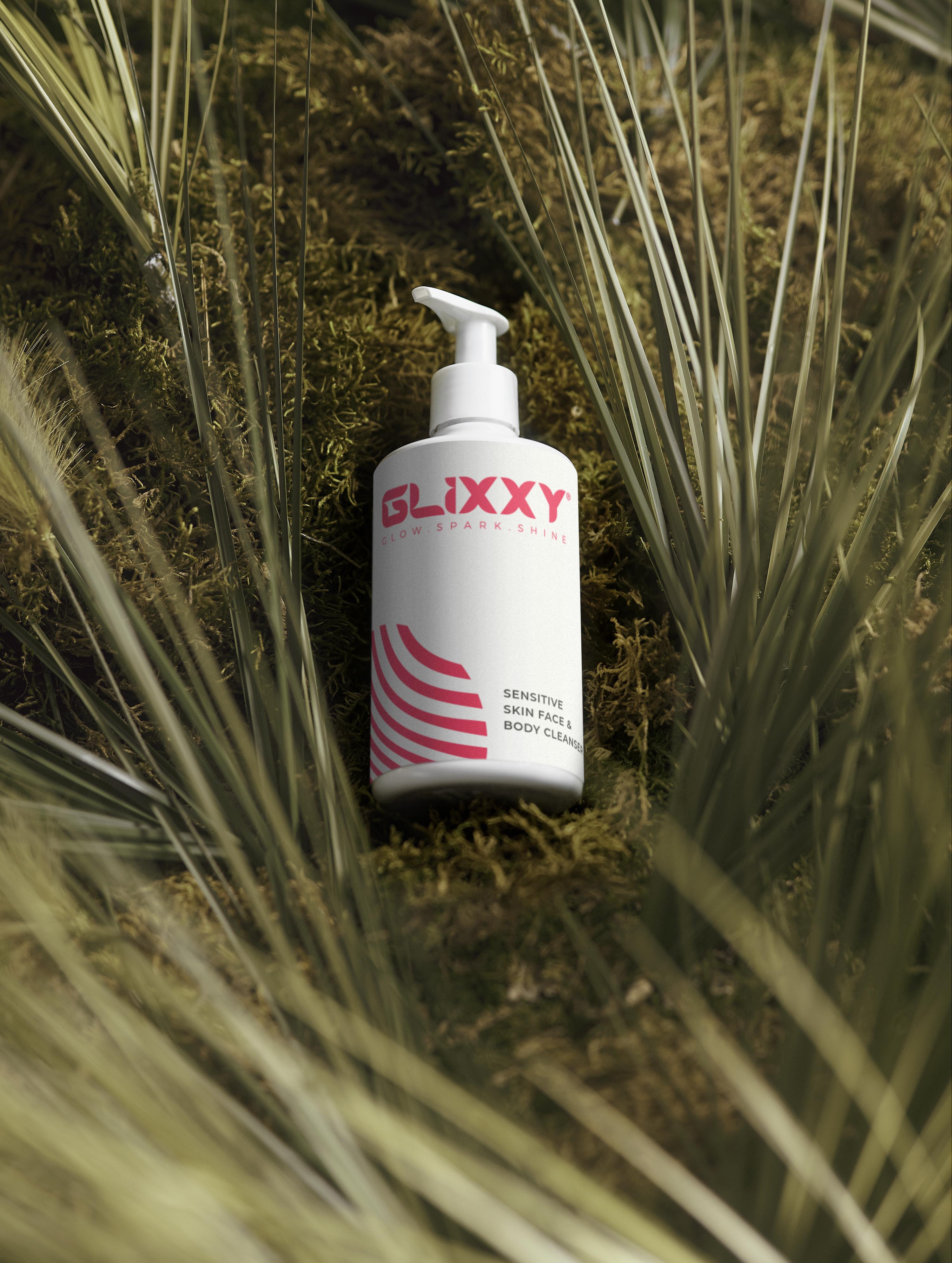 Glixxy organic cleanser for sensitive skin bottle on a natural background with plants