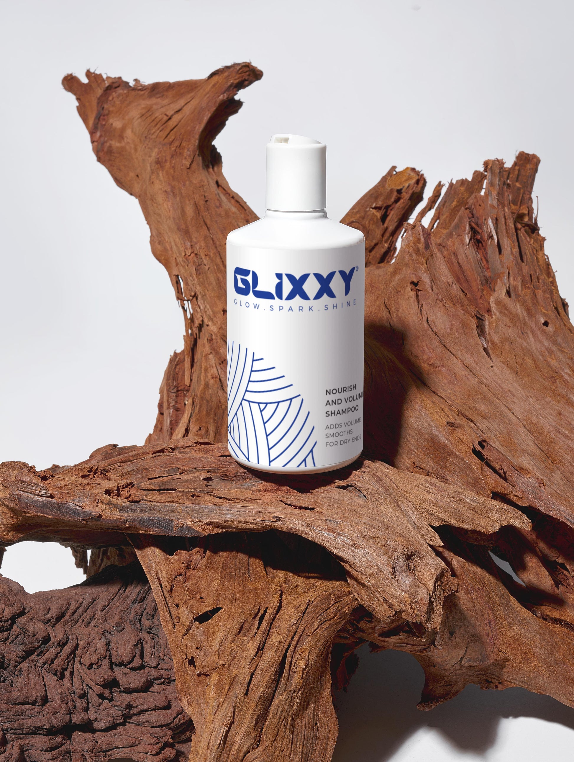 Glixxy best volumizing shampoo bottle on a wooden surface with a white background