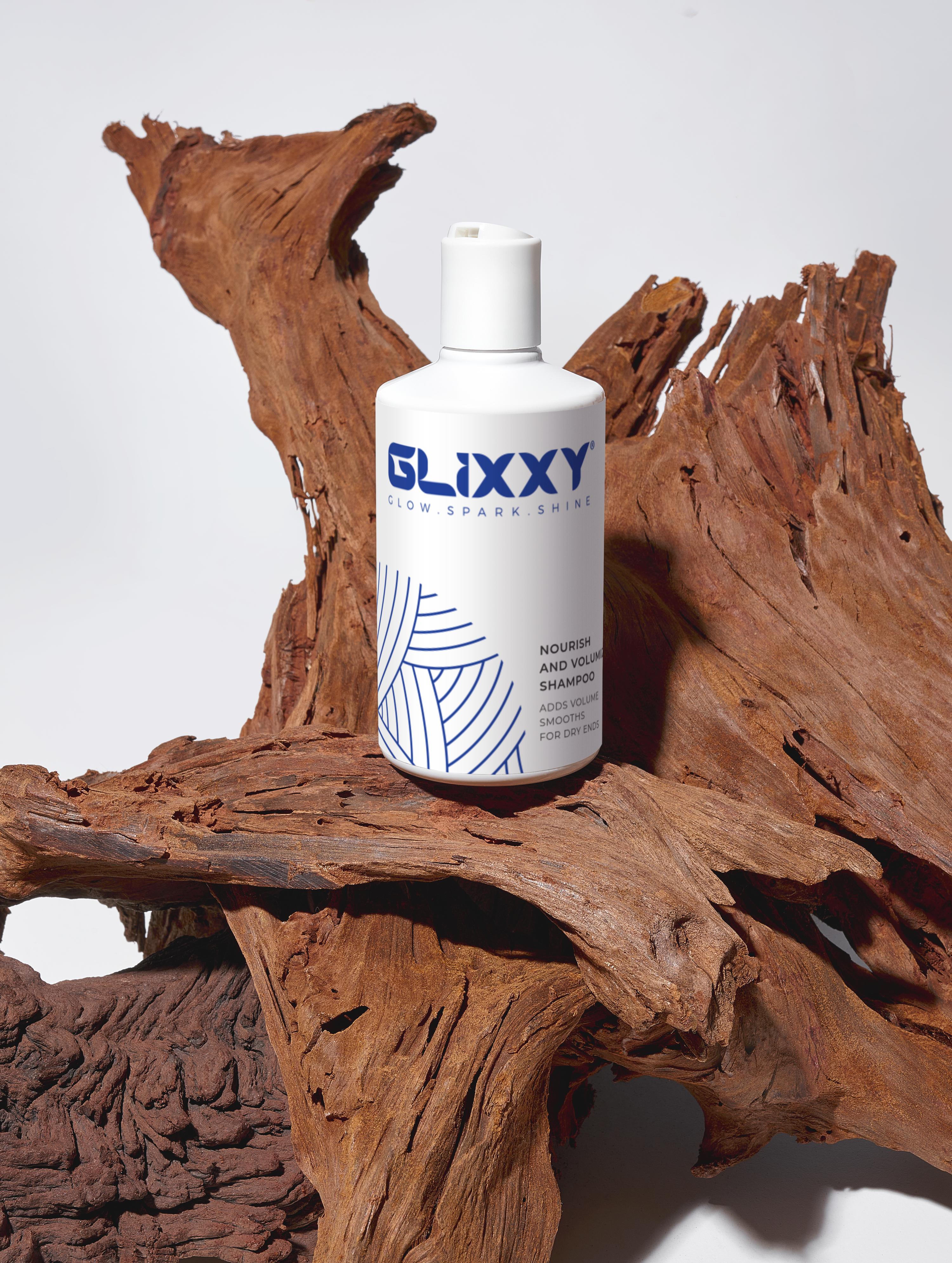 Glixxy best volumizing shampoo bottle on a wooden surface with a white background